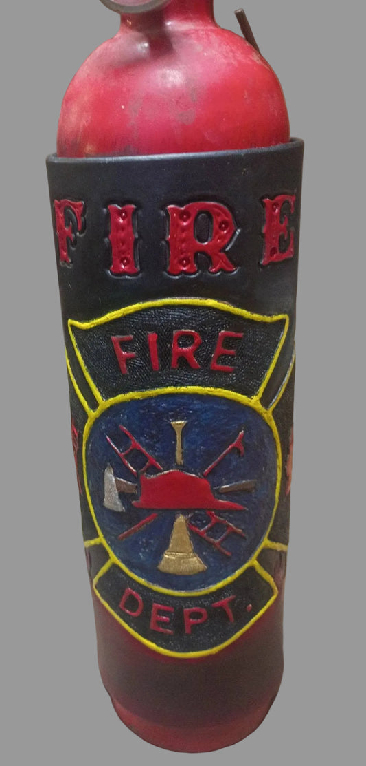 A red fire hydrant-shaped bottle or container with a black sleeve featuring embossed 'FIRE DEPT.' text and a yellow, blue, and red firefighter emblem, shown on a rustic wooden surface.
