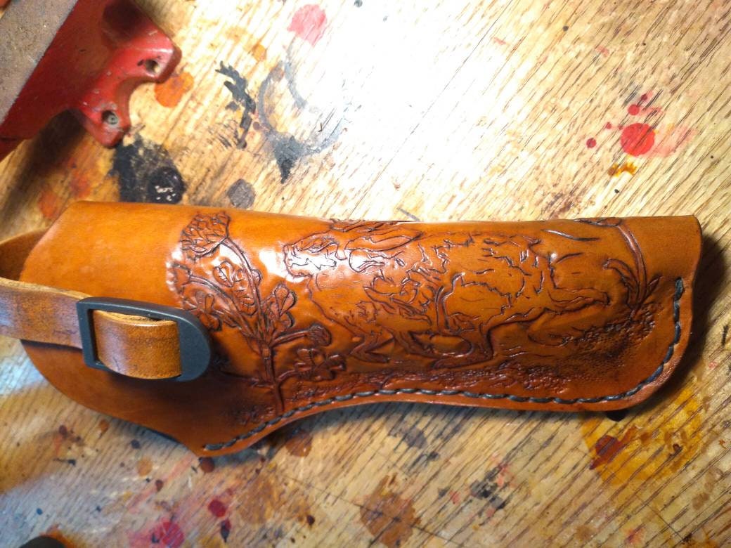 Handmade for left hand use. Freehand engraved and monogrammed, pistol holster for auto-loader or revolver with heavy duty clip mount.