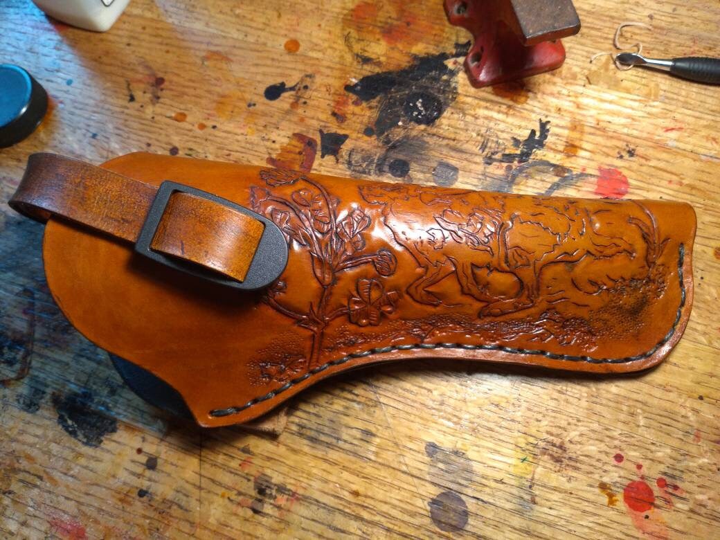 Pistol holster for auto-loader or revolver. Handmade for right handed use. Freehand engraved, monogrammed, and made from scratch.